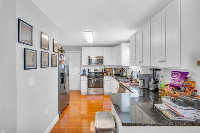 kitchen featuring white cabinets, appliances with stainless steel finishes, and kitchen peninsula