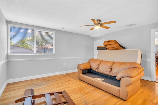 living room with light hardwood / wood-style floors and ceiling fan