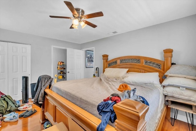 bedroom with ceiling fan, light hardwood / wood-style flooring, and a closet