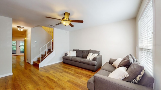 living room with ceiling fan, light hardwood / wood-style floors, and french doors