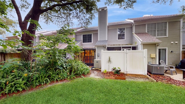 rear view of property featuring a patio and a yard