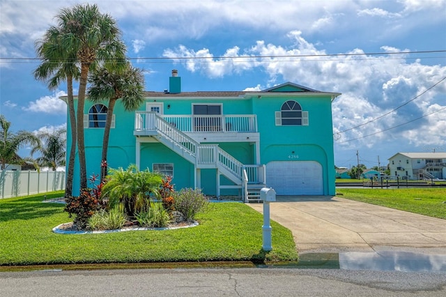 coastal home with a front yard and a garage