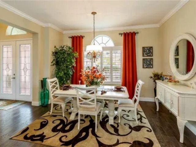 dining area featuring crown molding, dark hardwood / wood-style floors, and a healthy amount of sunlight