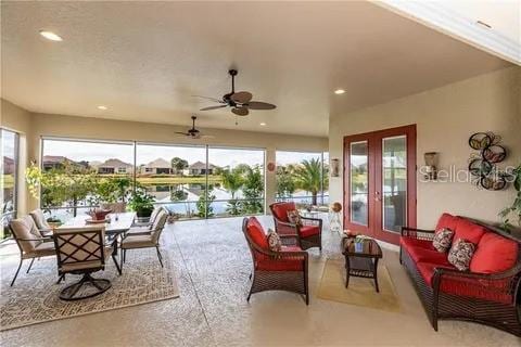 sunroom with a water view and ceiling fan