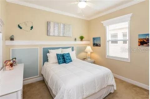 carpeted bedroom featuring ceiling fan and crown molding