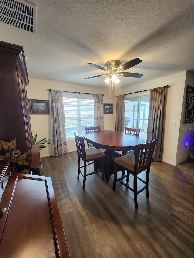 dining space with a textured ceiling, dark wood-type flooring, and ceiling fan