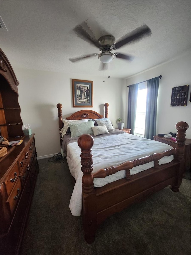 bedroom with a textured ceiling, ceiling fan, and dark colored carpet