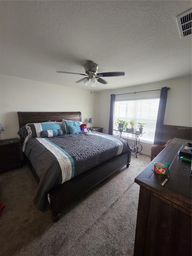 bedroom with a textured ceiling, ceiling fan, and carpet floors