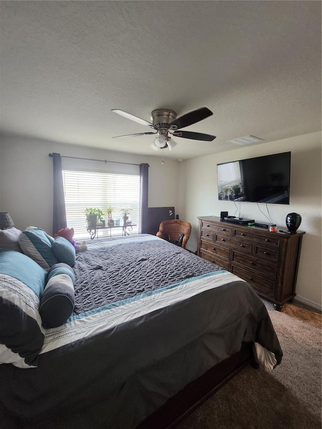 bedroom featuring a textured ceiling, ceiling fan, and carpet flooring