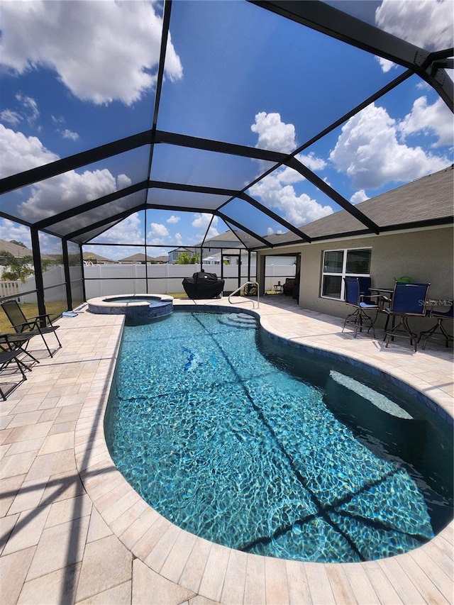 view of swimming pool with glass enclosure, an in ground hot tub, and a patio