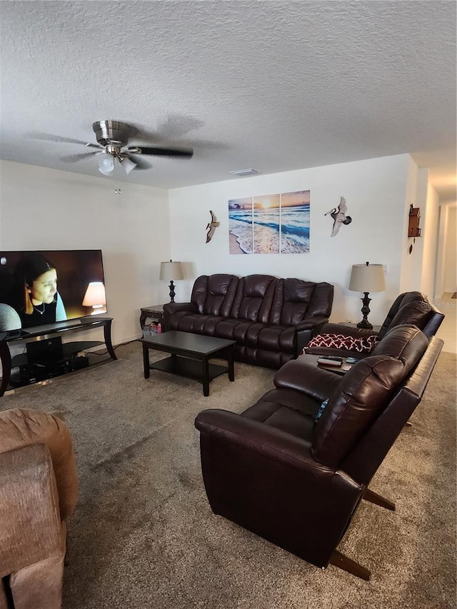 carpeted living room with ceiling fan and a textured ceiling