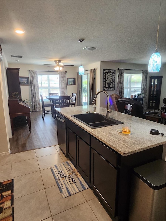 kitchen featuring decorative light fixtures, light hardwood / wood-style flooring, an island with sink, sink, and ceiling fan