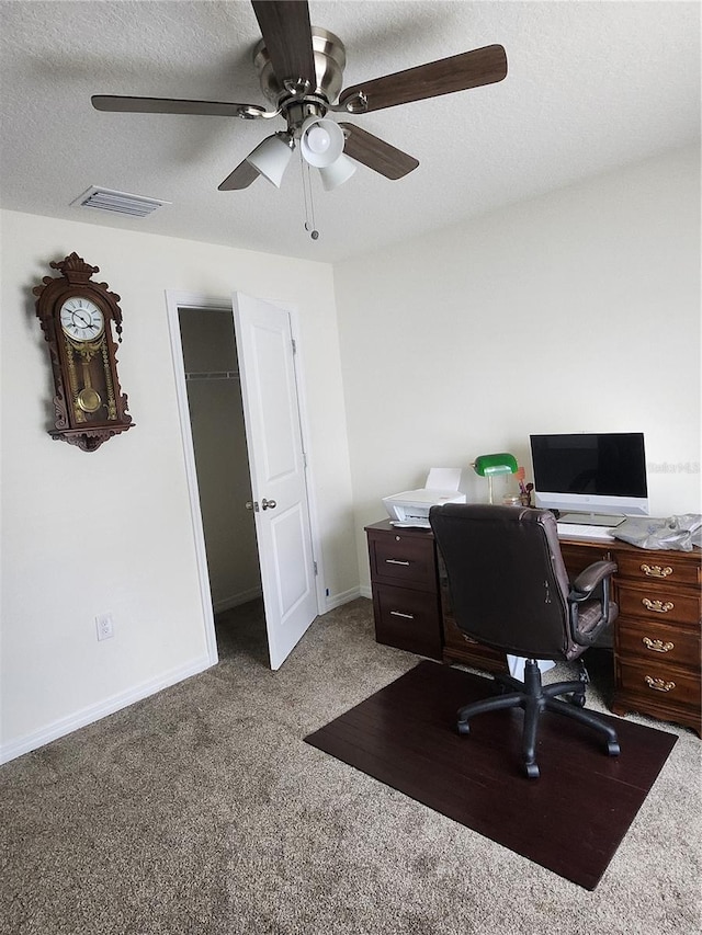 home office with a textured ceiling, carpet flooring, and ceiling fan