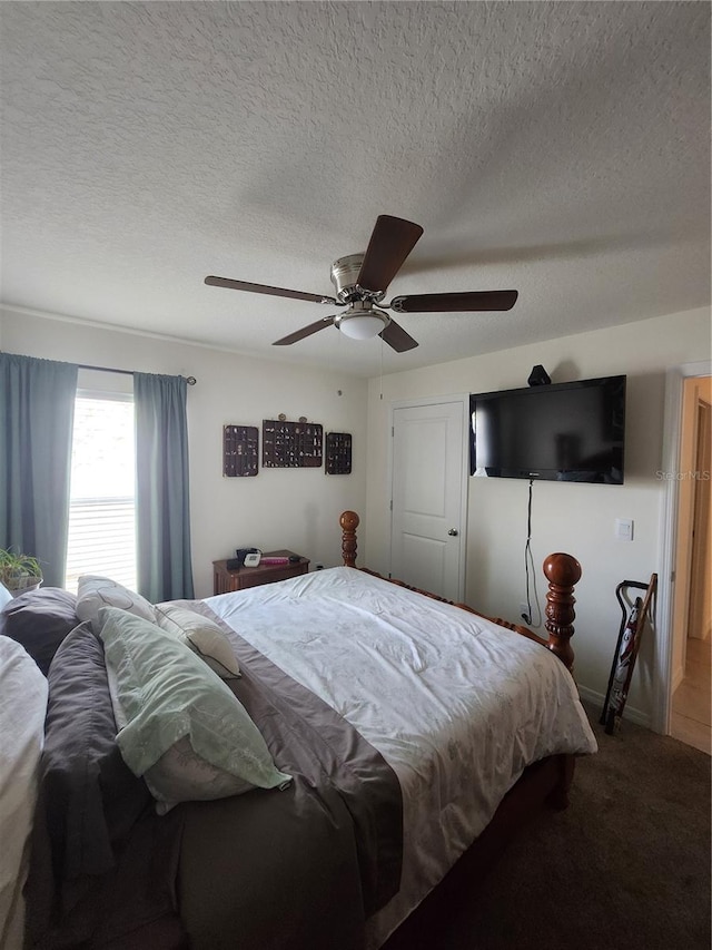 carpeted bedroom featuring ceiling fan and a textured ceiling