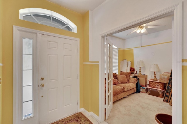 entryway featuring ceiling fan and light carpet