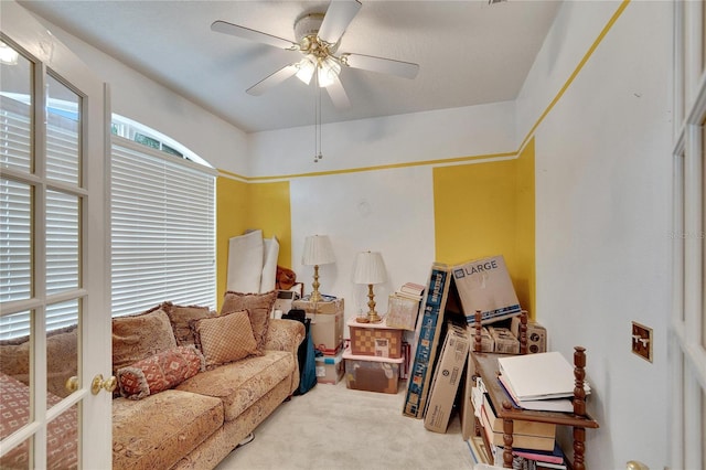 living area with carpet flooring and ceiling fan