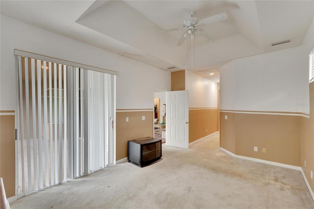 carpeted empty room featuring a raised ceiling and ceiling fan