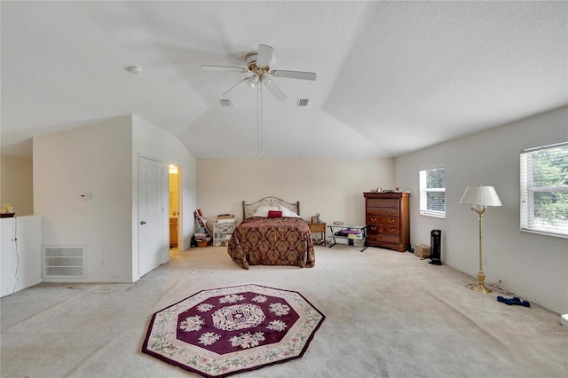 carpeted bedroom featuring ceiling fan, vaulted ceiling, and a textured ceiling