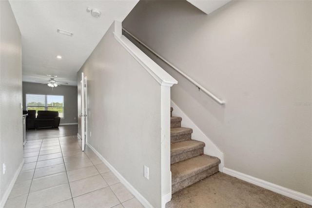 stairway featuring tile patterned flooring and ceiling fan