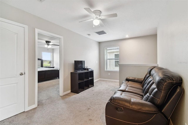 carpeted living room with ceiling fan