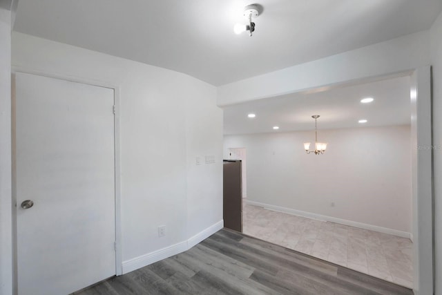 empty room with tile flooring and an inviting chandelier