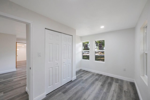 unfurnished bedroom featuring a closet and dark hardwood / wood-style flooring