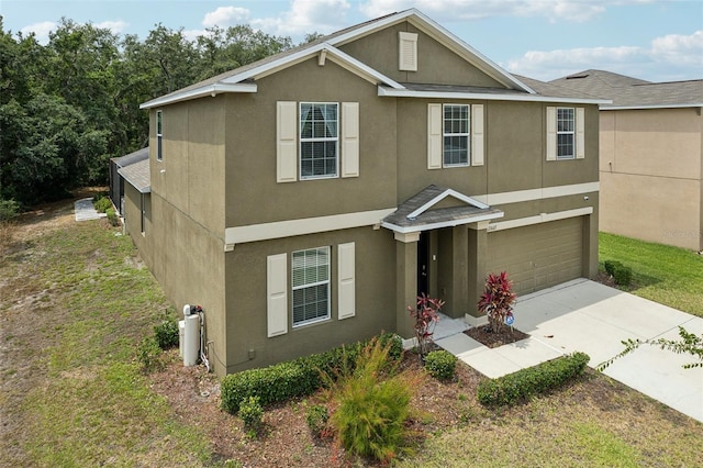 view of front of home featuring concrete driveway, an attached garage, and stucco siding