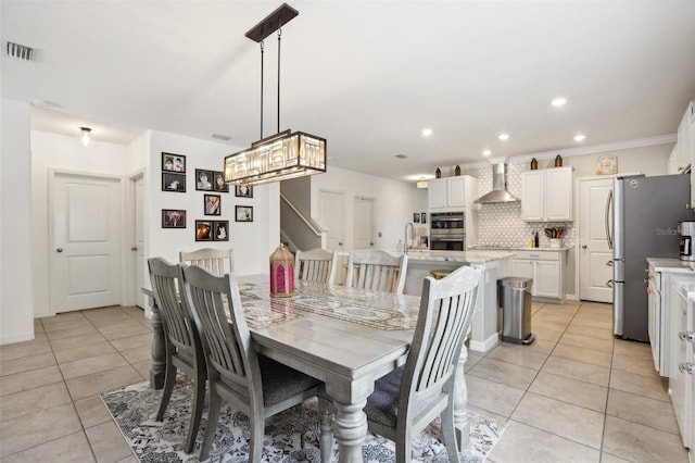 tiled dining room with sink and ornamental molding