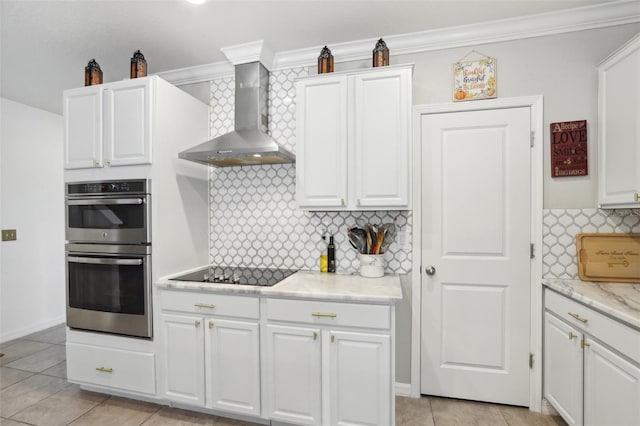 kitchen with double oven, black electric stovetop, tasteful backsplash, crown molding, and wall chimney exhaust hood