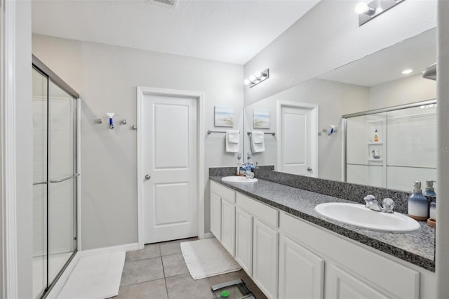 bathroom featuring tile floors, walk in shower, and double vanity