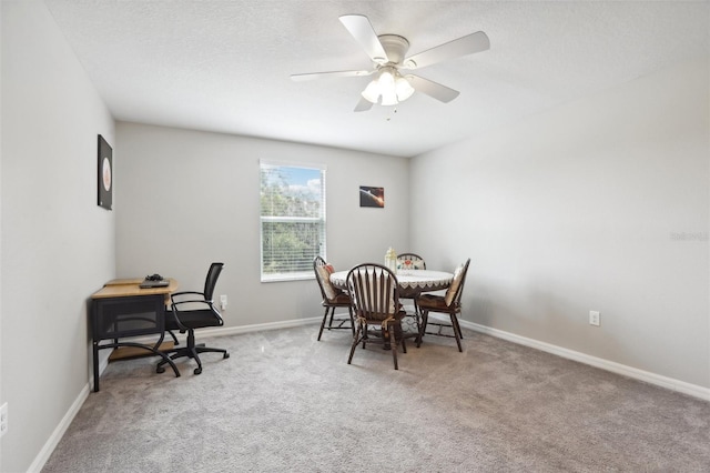 home office with a ceiling fan, baseboards, a textured ceiling, and light colored carpet