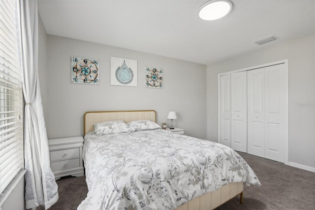 bedroom featuring dark colored carpet, a closet, visible vents, and baseboards