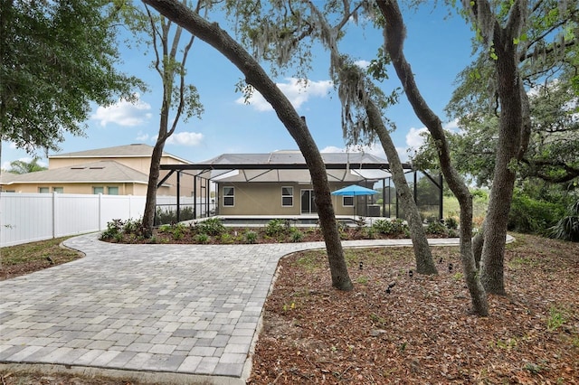 view of front of home featuring glass enclosure and fence