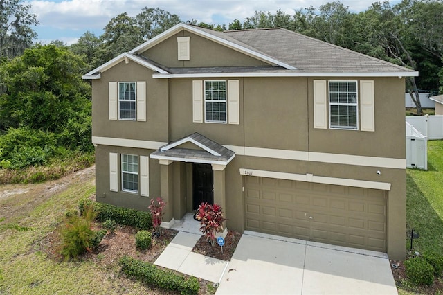 view of front of home featuring driveway, an attached garage, and stucco siding