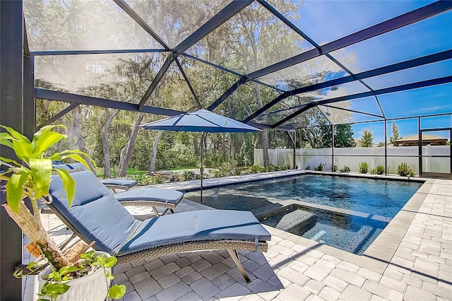 view of swimming pool with glass enclosure, a patio area, a fenced in pool, and an in ground hot tub