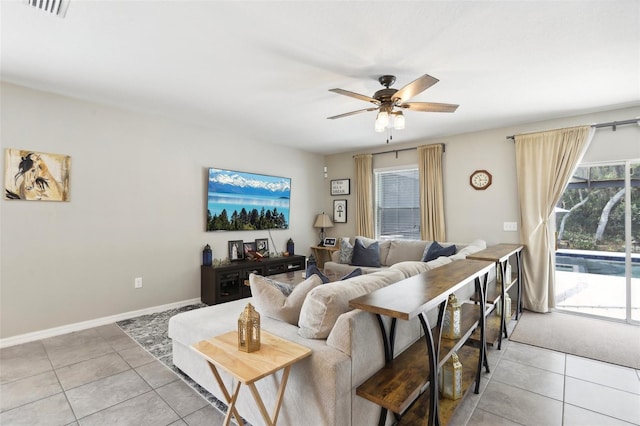 living area featuring a ceiling fan, a wealth of natural light, light tile patterned flooring, and visible vents