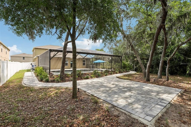 back of house featuring glass enclosure and fence