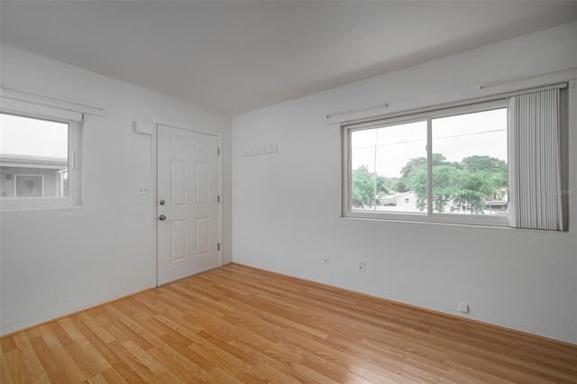 spare room featuring light hardwood / wood-style flooring and a healthy amount of sunlight