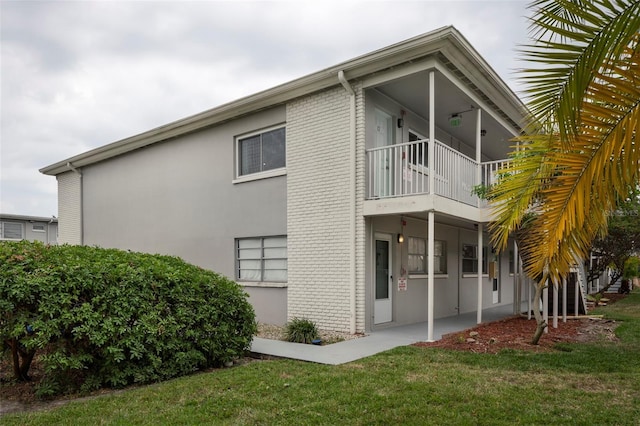 rear view of property featuring a yard and a balcony