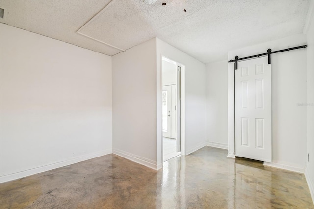 basement featuring a textured ceiling and a barn door