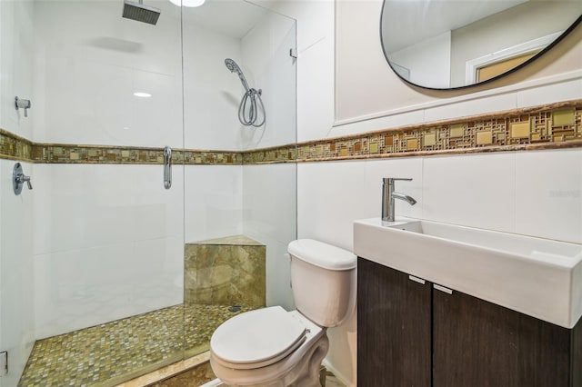 bathroom with vanity, toilet, tile walls, and walk in shower