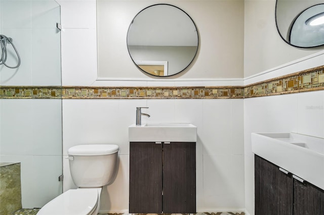 bathroom featuring vanity, tile walls, and toilet