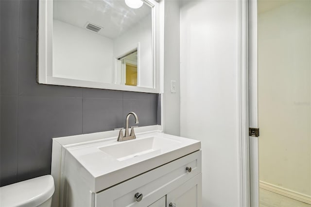 bathroom featuring decorative backsplash, vanity, and toilet