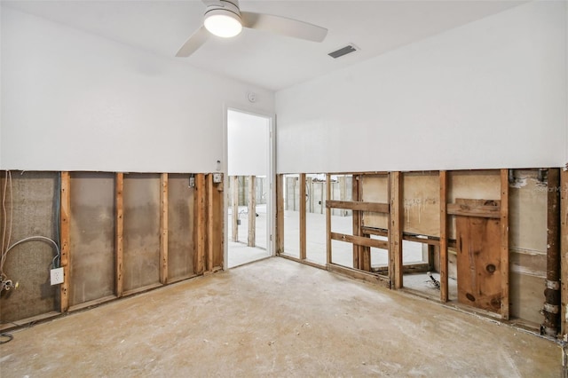 unfurnished room with ceiling fan and concrete flooring