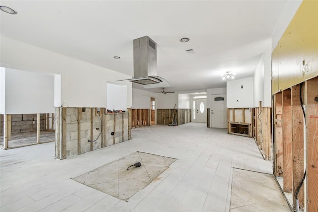 interior space with ceiling fan and wooden walls