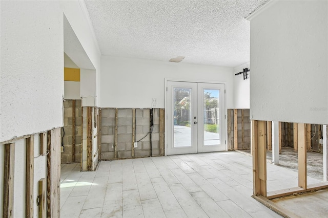 interior space featuring a textured ceiling and french doors