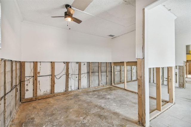 basement featuring a textured ceiling and ceiling fan