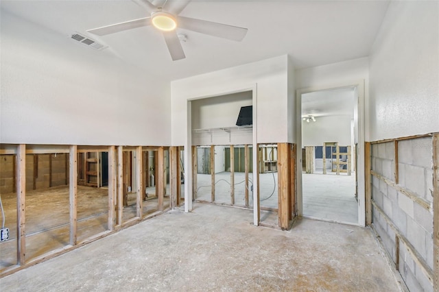 unfurnished room with ceiling fan and concrete floors