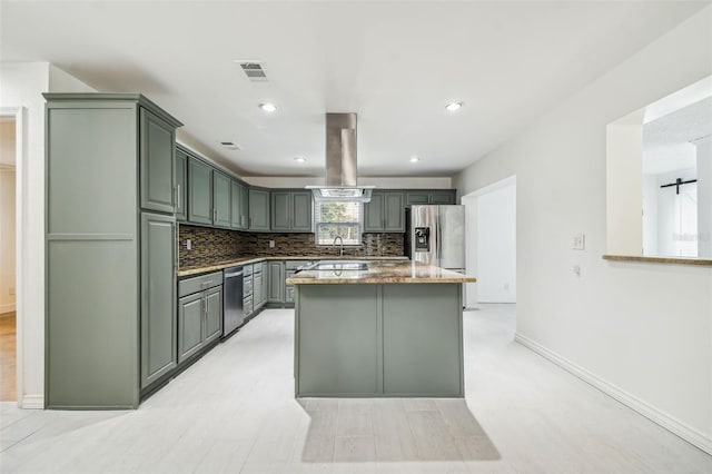 kitchen with decorative backsplash, appliances with stainless steel finishes, stone countertops, light hardwood / wood-style floors, and island exhaust hood