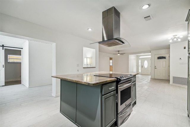 kitchen featuring a center island, electric stove, a barn door, plenty of natural light, and island exhaust hood